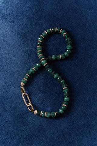 BOUJEE BEADS GREEN BRACELET LAID OUT AGAINST A BLUE BACKGROUND