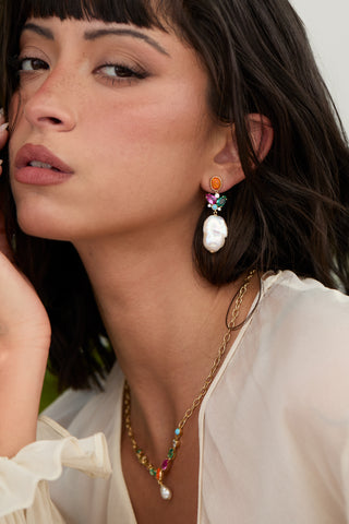 CLOSE UP OF A MODEL’S FACE WEARING THE FRIEDA LARGE FRESHWATER PEARL DROP EARRINGS AND FRONTAL NECKLACE