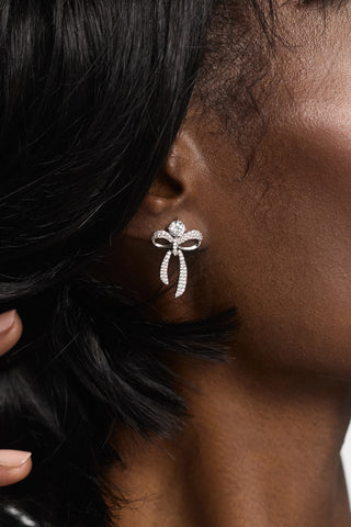 CLOSE UP OF A MODEL’S EAR WEARING THE EROS SMALL BOW AND CZ EARRINGS