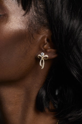 CLOSE UP OF A MODEL’S EAR WEARING THE EROS SMALL BOW AND CZ EARRINGS