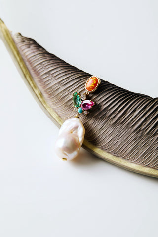 FRIEDA LARGE FRESHWATER PEARL DROP EARRINGS LAID AGAINST A LEAF
