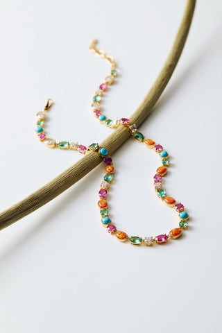 FRIEDA FULL COLLAR NECKLACE DRAPED OVER A GREEN STEM