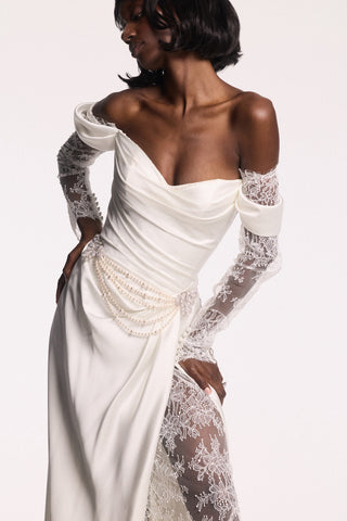 A MODEL POSING IN A WHITE WEDDING GOWN AND THE PEARL SWAG BROOCH BELT