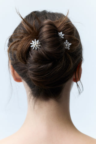 CLOSE-UP OF THE BACK OF A WOMAN’S HEAD WITH BRUNETTE HAIR STYLED IN A BUN, FEATURING NADRI’S MARQUISE CLUSTER CZ SET OF 3 BOBBY PINS PINNED THROUGHOUT THE BUN.