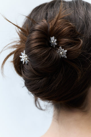 CLOSE-UP OF THE BACK OF A WOMAN’S HEAD WITH BRUNETTE HAIR STYLED IN A BUN, FEATURING NADRI’S MARQUISE CLUSTER CZ SET OF 3 BOBBY PINS PINNED THROUGHOUT THE BUN.