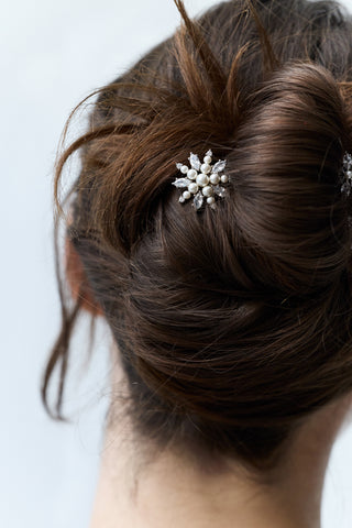 CLOSE-UP OF THE BACK OF A WOMAN’S HEAD WITH BRUNETTE HAIR STYLED IN A BUN, FEATURING NADRI’S MARQUISE CLUSTER CZ SET OF 3 BOBBY PINS PINNED THROUGHOUT THE BUN.