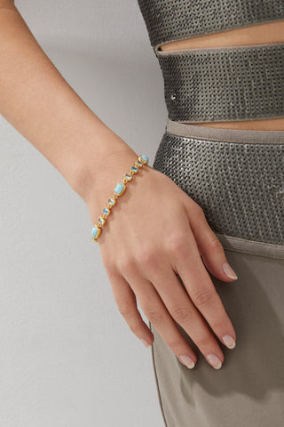 CLOSE UP OF MODEL'S ARM WEARING CABARETE MULTI LINE BRACELET. SHE IS IN A METALLIC GOWN. 