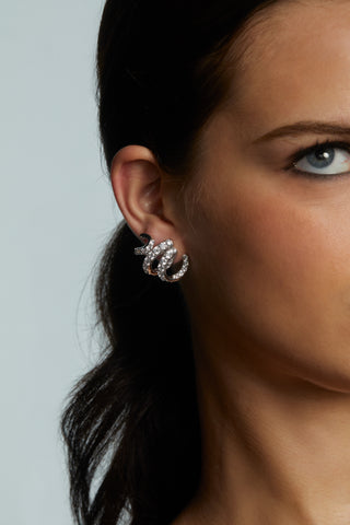 CLOSEUP IMAGE OF MODEL WEARING BONNE ANNÉE RIBBON STUD EARRINGS IN RHODIUM PLATING