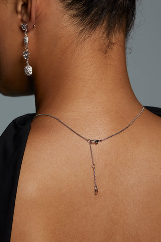BACK VIEW OF MODEL WEARING CRUSHED PAVE CUSHION DROP NECKLACE WITH A DETAIL OF THE CHAIN AND LOBSTER CLASP CLOSURE. 
