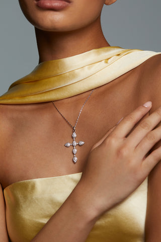 MODEL WEARING CRUSHED HALO CROSS PENDANT NECKLACE. SHE HAS ON A YELLOW SILK STRAPLESS DRESS WITH A MATCHING SCARF. 