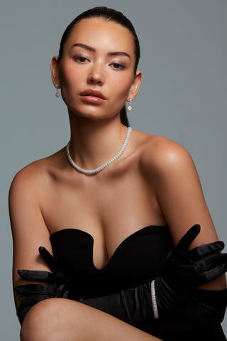 MODEL WEARING CRUSHED PAVE DOME BRACELET. SHE HAS HER HAIR PULLED BACK INTO A SLICK PONYTAIL AND IS WEARING THE CRUSHED PAVE CZ DROP EARRINGS AND THE PAVE CZ COLLAR NECKLACE WITH A STRAPLESS BLACK DRESS AND BLACK LONG SILK GLOVES. 