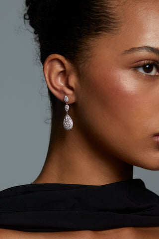 CLOSE UP IMAGE OF MODEL WEARING CRUSHED PAVE TRIPLE DROP EARRINGS. HER HAIR IS PULLED BACK INTO A BUN AND SHE HAS ON BLACK SILK SCARF.
