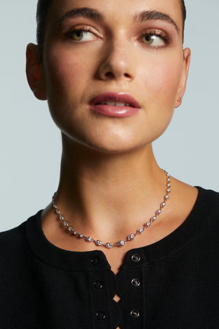 CLOSE UP OF MODEL WEARING IT GIRL CHAIN COLLAR NECKLACE WITH HER HAIR UP IN A BUN AND WEARING A BLACK BUTTON DOWN BLOUSE.