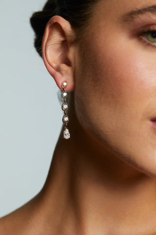 CLOSE UP OF MODEL WEARING IT GIRL LINEAR EARRINGS IN GOLD PLATING