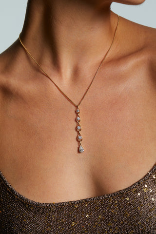 CLOSE UP OF MODEL WEARING IT GIRL Y PENDANT NECKLACE WITH A BROWN SHIMMERY TOP