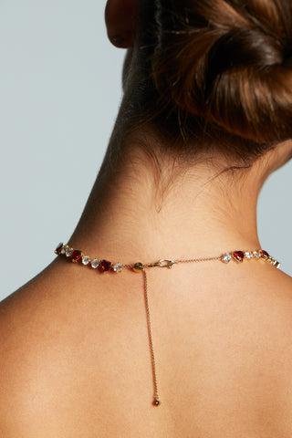 BACK VIEW OF MODEL WEARING LE BISOU RED HEART COLLAR NECKLACE WITH HER HAIR UP IN A BUN. DETAIL SHOT OF THE CLASP CLOSURE WITH THE ADJUSTABLE BOLO.