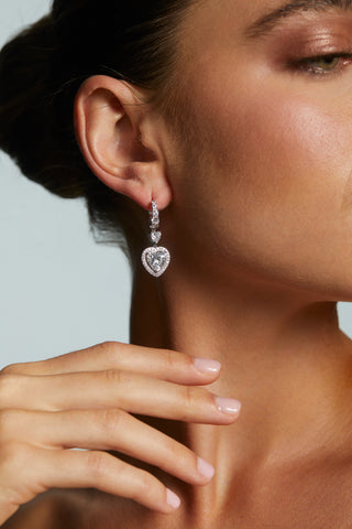 Close-up of a woman LE BISOU HALO HEART LEVERBACK EARRINGS with a blurred background