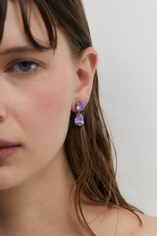 CLOSE UP OF A MODEL WEARING MAIDEN LEVERBACK PEAR DROP EARRINGS, WITH HAIR TUCKED BEHIND HER EAR AND HALF OF HER FACE IN FRAME