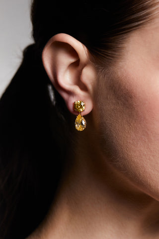 CLOSE UP OF A MODEL’S EAR WEARING MAIDEN YW PEAR DROP EARRINGS WITH HER HAIR IN A PONYTAIL