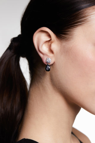 CLOSE UP OF MODEL’S PROFILE  WEARING MAIDEN BLACK PEAR DROP EARRINGS WITH HER HAIR IN A PONYTAIL.