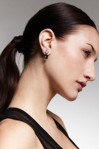 SIDE-PROFILE VIEW OF A MODEL WEARING MAIDEN BLACK PEAR DROP EARRINGS WITH HER HAIR IN A PONYTAIL.