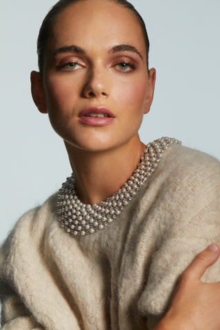 RBG PEARL XL WIDE COLLAR NECKLACE ON MODEL WEARING A SWEATER. THE CLASP IS STYLED AT THE BACK OF THE NECKLACE.