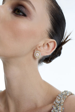 CLOSE UP OF A MODEL’S EAR AS SHE LOOKS UPWARD, WEARING A GOLD SPARKLY DRESS AND THE FRANCES OVAL BUTTON EARRINGS