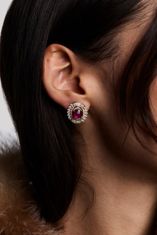 CLOSE UP OF A MODEL’S EAR WITH BROWN HAIR, WEARING A BROWN FUR JACKET AND THE FRANCES RED OVAL BUTTON EARRINGS