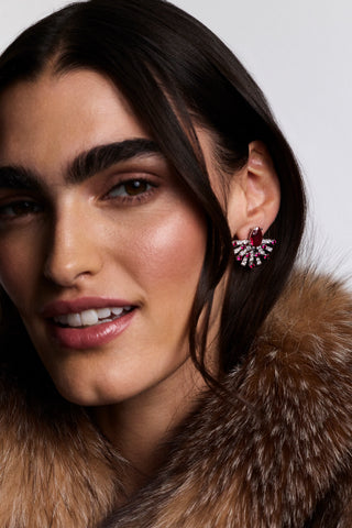 MODEL LOOKING AT THE CAMERA AS SHE WEARS A BROWN FUR JACKET AND THE FRANCES PINK FLARE STUD EARRINGS