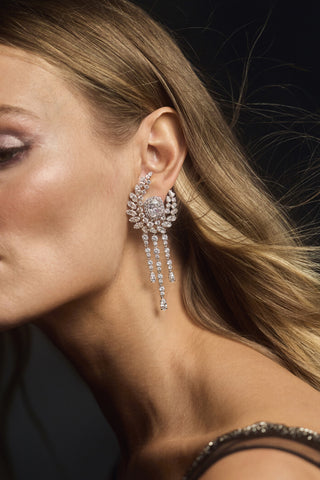 CLOSE UP OF THE SIDE PROFILE OF A MODEL AS HER BLONDE HAIR BLOWS BEHIND HER AND SHE WEARS THE FRANCES CHANDELIER EARRINGS