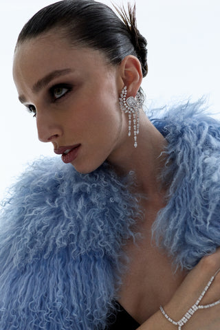 SIDE PROFILE OF A MODEL LOOKING UPWARD WEARING A BIG BLUE FUR COAT AND THE FRANCES CHANDELIER EARRINGS