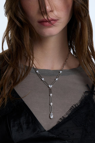 CLOSE UP OF A MODEL’S CHEST WEARING A BLACK LACE CAMI LAYERED OVER A GRAY TOP AND THE SUPERNOVA LONG LINK Y NECKLACE