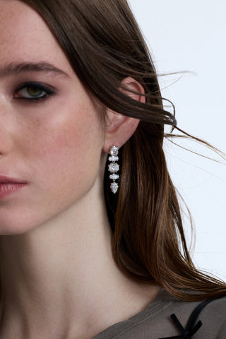 HALF OF A MODEL’S FACE IN FRAME WITH HER HAIR BLOWING TO HER SIDE, WEARING THE SUPERNOVA LINEAR EARRINGS