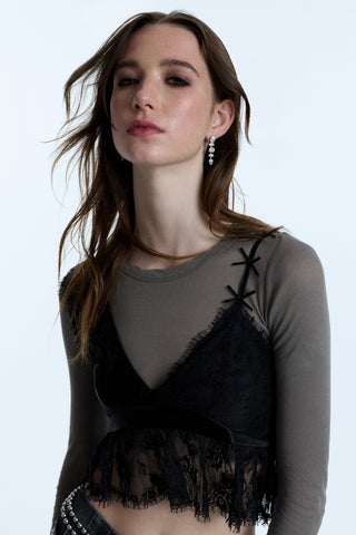 A MODEL WEARING A BLACK LACE CAMI LAYERED OVER A GRAY LONG SLEEVE, PAIRED WITH THE SUPERNOVA LINEAR EARRINGS