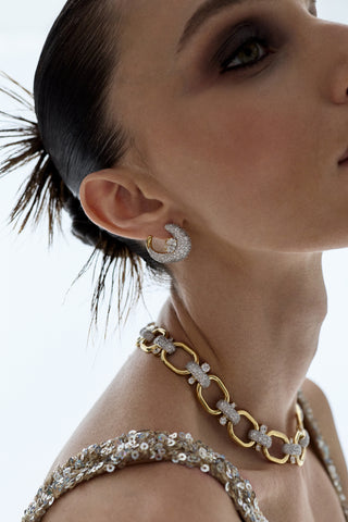 CLOSE UP OF THE SIDE PROFILE OF A MODEL, AS SHE WEARS A SPIKY BUN HAIRSTYLE AND THE TURN UP THE VOLUME FRONTBACK EARRINGS