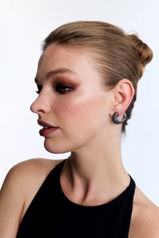 SIDE PROFILE OF A MODEL WEARING A BLACK TOP, SLICK-BACK HAIRDO, AND THE TURN UP THE VOLUME FRONTBACK EARRINGS