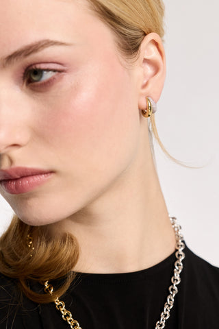 CLOSE UP OF HALF OF A MODEL’S FACE, AS SHE WEARS THE GEMINI DOUBLE ILLUSION HOOP EARRINGS AND LARGE LINK NECKLACE