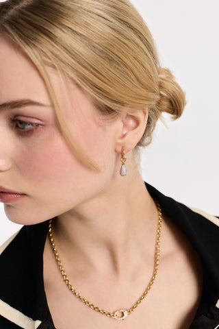 CLOSE UP OF A MODEL’S PROFILE WEARING THE GEMINI PAVE DROP HUGGIE EARRINGS AND THE GEMINI PAVE CLASP COLLAR NECKLACE