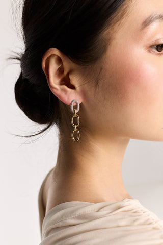 CLOSE UP OF A MODEL’S EAR WITH HER HAIR PULLED BACK WHILE WEARING THE GEMINI LINK DROP EARRINGS