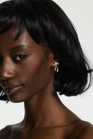 CLOSE UP OF A MODEL WITH SHORT HAIR LOOKING AT THE CAMERA, WEARING NADRI’S EROS SMALL BOW AND PEARL EARRINGS