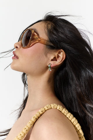 MODEL TURNED TO THE SIDE WITH BIG SUNGLASSES AND HAIR FLOWING BEHIND HER, WEARING THE MOJITO BLUE J HOOP EARRINGS