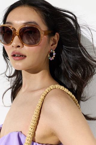 MODEL WITH HER HAIR BLOWING BEHIND HER, WEARING SUNGLASSES AND THE MOJITO MULTI FRONTBACK EARRINGS