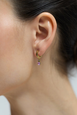 CLOSE UP OF A MODEL’S EAR WEARING THE DELANCEY PINK SMALL CHARM HOOP EARRINGS