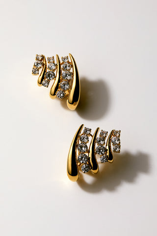 close up image of the Phenom Multi J Hoop earrings on a light background with a shadow.