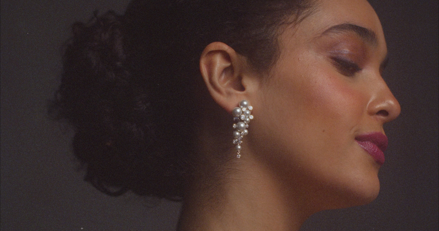 Video of model wearing Nadri's Under the Sea pearl cluster earrings and bracelet.  Her dark hair is pulled back and she is dancing and twirling in a voluminous black and white ostrich feather jacket and white gown.