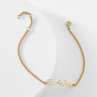 A gold chain bracelet that says "Boss Babe" with a cubic zirconia stone